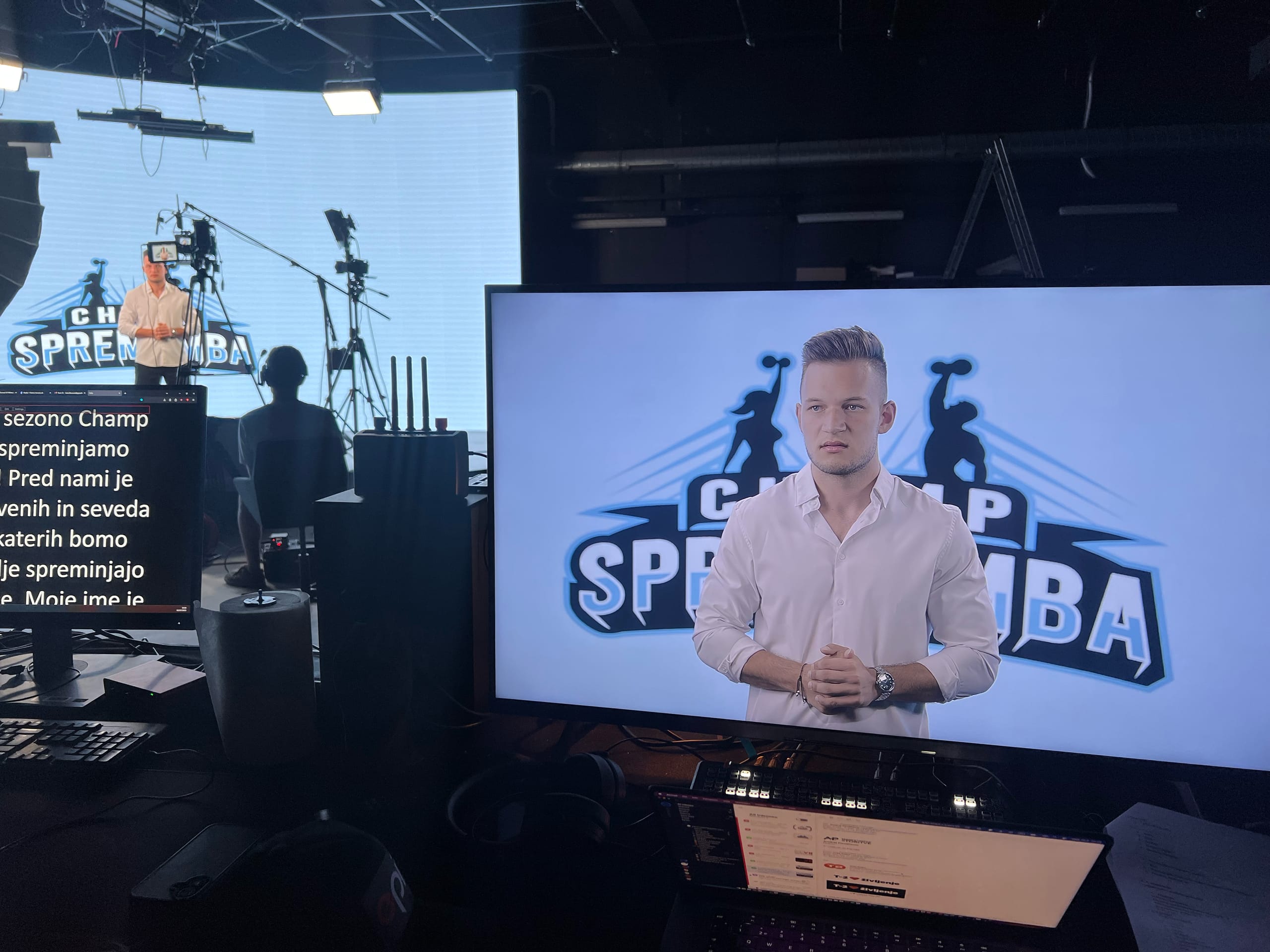TV studio z monitorjem, na katerem voditelj predstavlja oddajo Champ Sprememba.