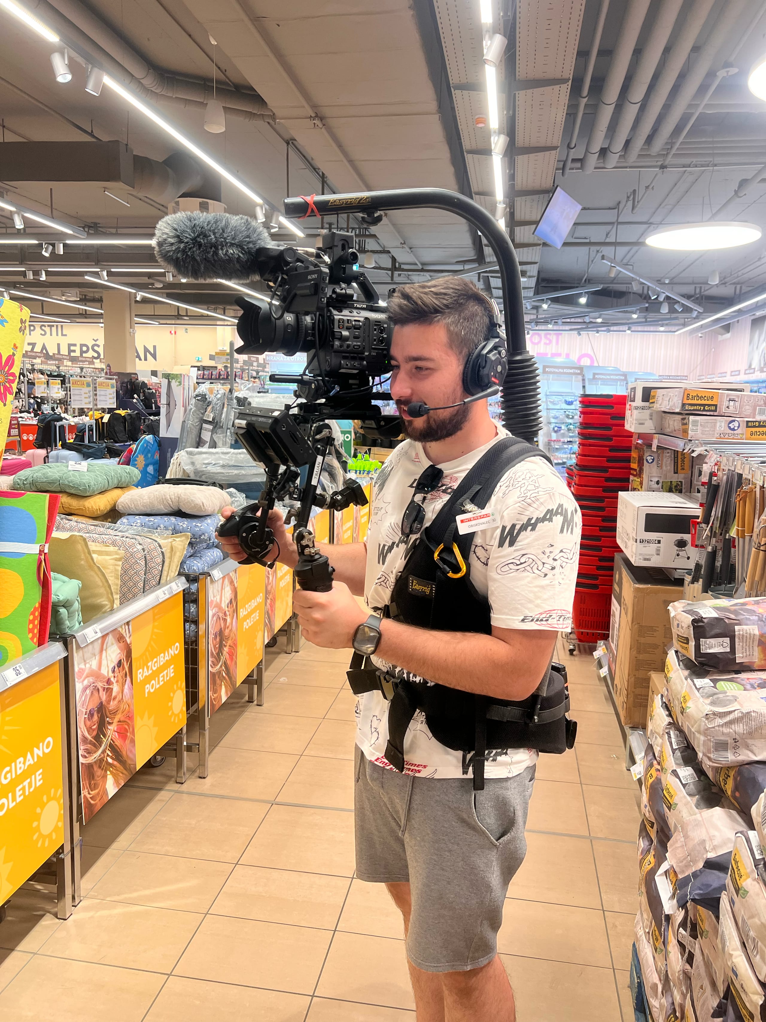 Snemalec z opremo na ramenskem stabilizatorju snema v trgovini z izdelki.
