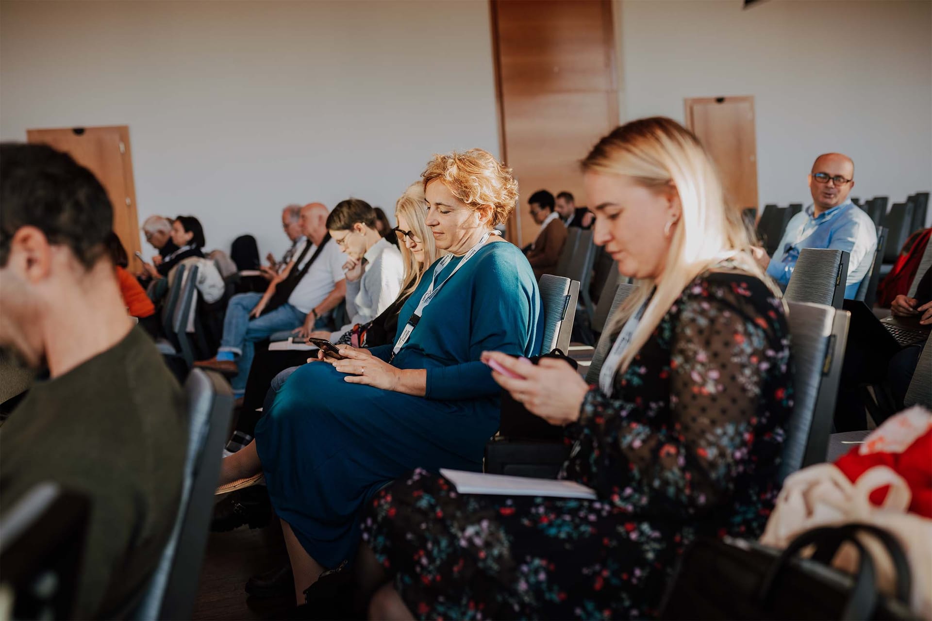 Udeleženci sedijo v konferenčni dvorani med odmorom dogodka.