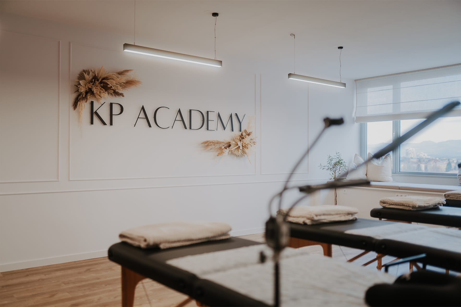 Učilnica z napisom KP Academy, ležalniki in svetlobnimi lučmi na stropu.
