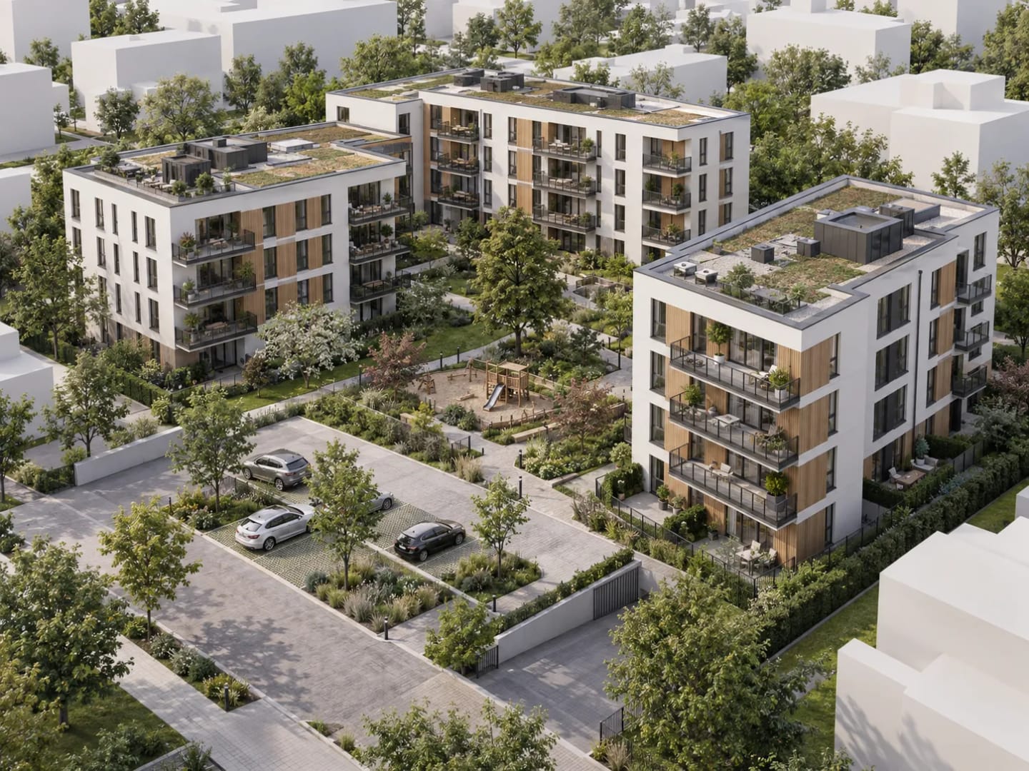 Aerial view of a residential complex with three blocks, green roofs and a landscaped courtyard.